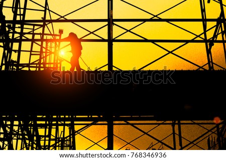 silhouette of construction worker construction worker on construction site , industry background