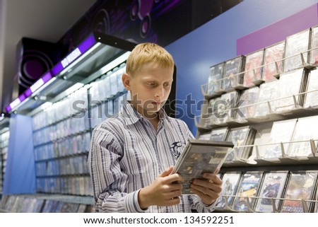 Teenage Boy Shopping in Computer Game Shop by Stand