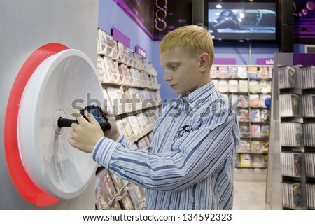 Teenage Boy Playing Computer Game in Store