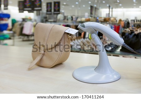 Handbad in fashion clothing store.  Scanner on sales counter in shop.