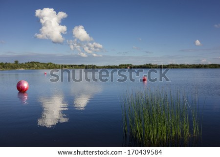 Marked area for motor sport and jetski. Red balls, buoys in water. Clouds reflection on water. Estonia.