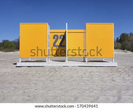 Yellow dressing cabin, changing cubicle number 22  on empty beach in Estonia. Changing room.