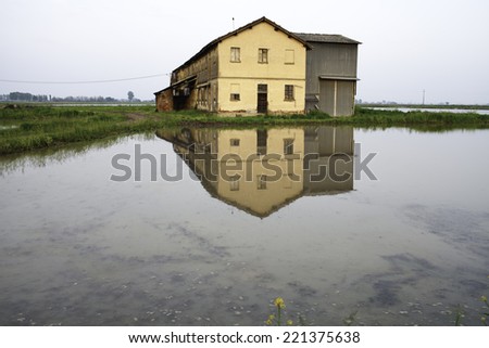 Lomellina, Pavia Northern Italy: farmhouse reflected in a water-filled paddy field. Color image