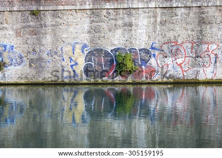 MILAN, ITALY - JULY 21: some graffiti painted along the wall over the \