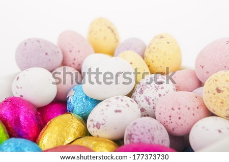 Dish of Chocolate Easter Eggs A white dish of chocolate easter eggs, some wrapped in colored silver paper.