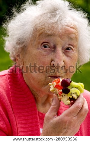 Senior Lady Eating A Waffle\
A senior lady eating a fresh cream and fruit waffle, on a summers day in the garden
