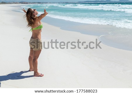 Happy woman with opened arms on the beach. Rio de Janeiro, Arraial do Cabo, Rocket Beach.