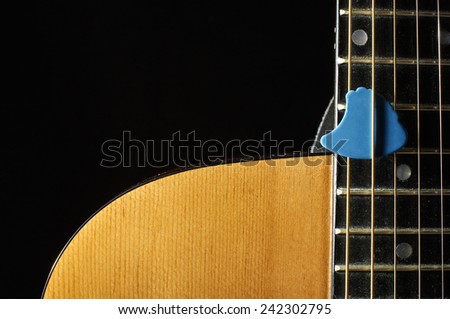 Close up of beautiful guitar body and blue guitar pick
