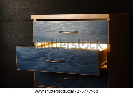 Mystery concept light from open drawer in the darkness