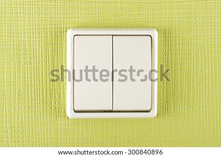 White plastic electricity switch on the green wall