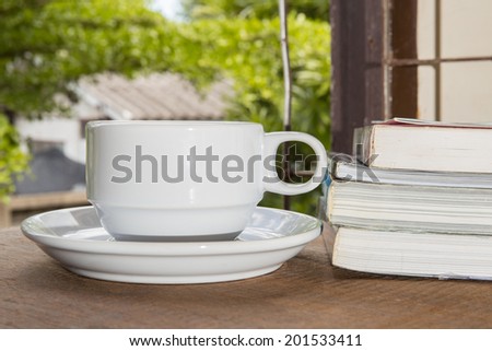 Cup of coffee, books, on table