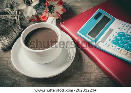 Cup of coffee, books and caculator on table wood