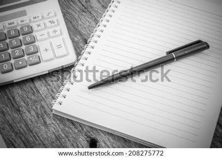note paper,pen and calculator on wooden table