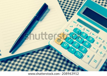 note paper with calculator and pen on table, vintage filter