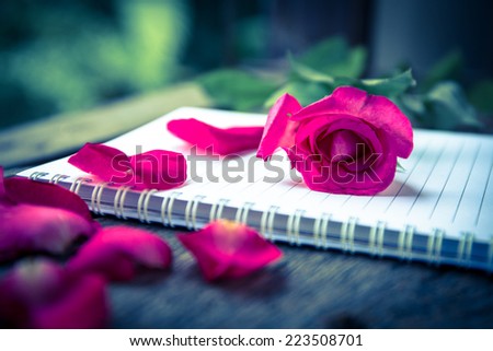 rose flower and notebook on table