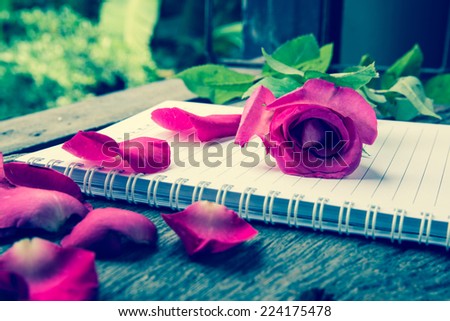 rose flower and notebook on table
