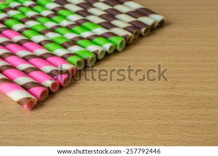 Closeup pink stripe wafer rolls on table.