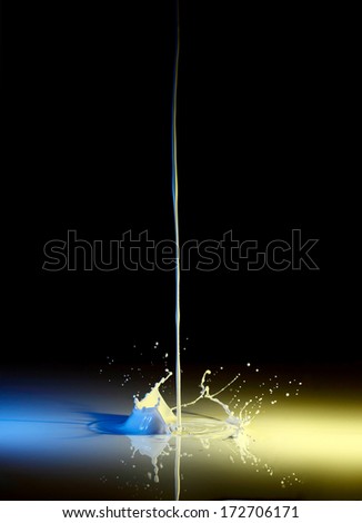 Colorful paint or milk splashing on black background