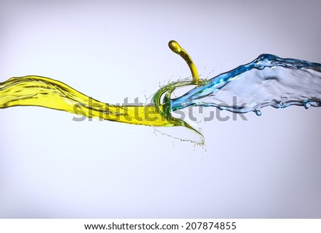 clash of yellow and blue liquid jets isolated in white background