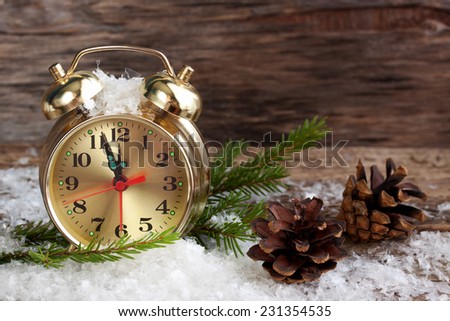clock on a wooden surface with snow