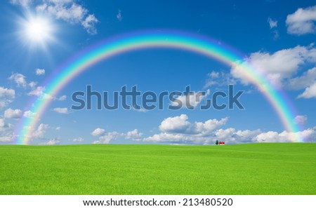 Green grass and red roof house and rainbow