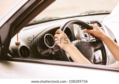 Hands of beautiful young woman in car.