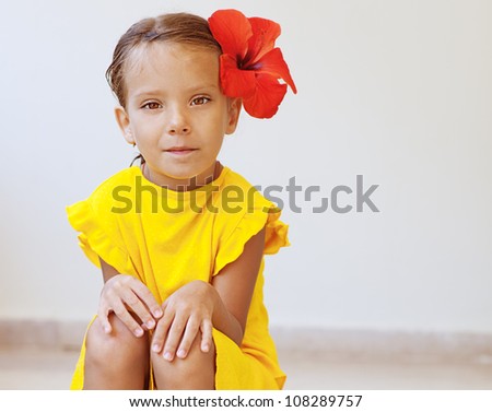   Dress on Beautiful Little Girl In Yellow Dress With Red Flower Sits On Stone