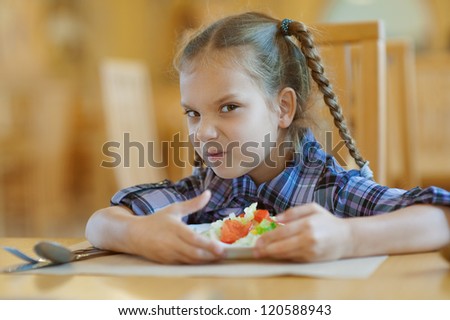 Beautiful little girl does not want to share meal in restaurant.