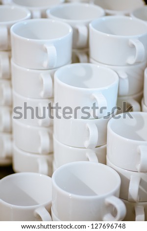 Many white mugs in several rows.
