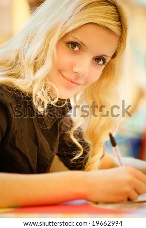 The young woman-student performs written work