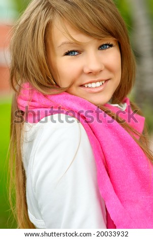 Young beautiful woman with dark blue eyes in white jacket laughs.