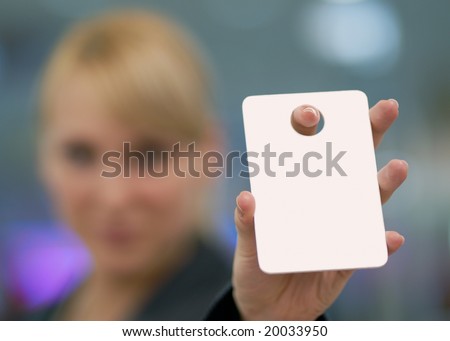 Young beautiful woman holding out card, on which it is possible to put your record.