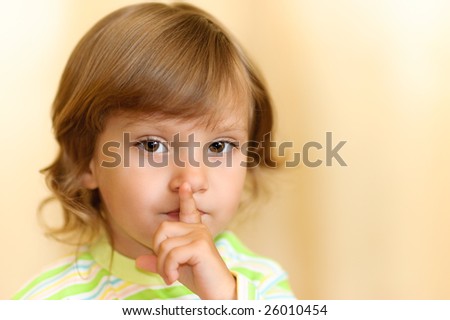 The beautiful little girl has put a finger to lips as sign of that all have become silent.