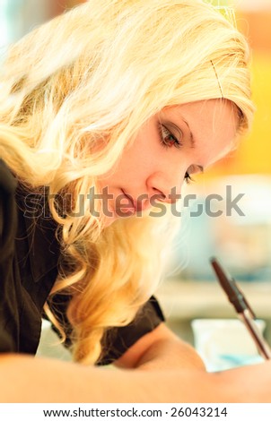 Young woman-student performs written work