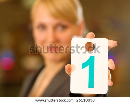 Young businesswoman shows white card with figure one