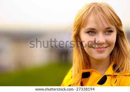 Young beautiful woman in bright yellow dress looks afar.