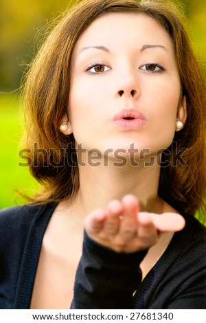 Young beautiful woman sends an air kiss.