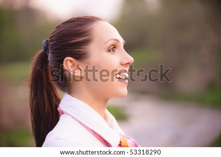 Portrait of smiling girl in profile against autumn nature.