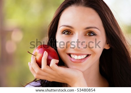 Smiling young woman with red apple