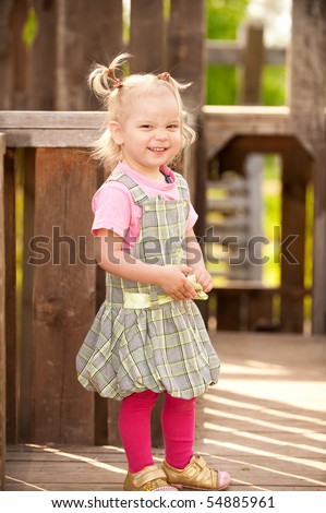 Little girl in wooden children\'s small town.