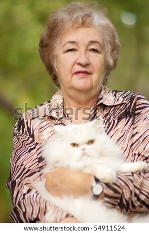 Elderly woman has control over white fluffy Persian cat.
