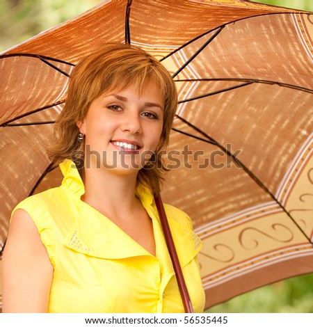 Beautiful smiling girl with sun-protection umbrella against summer nature.