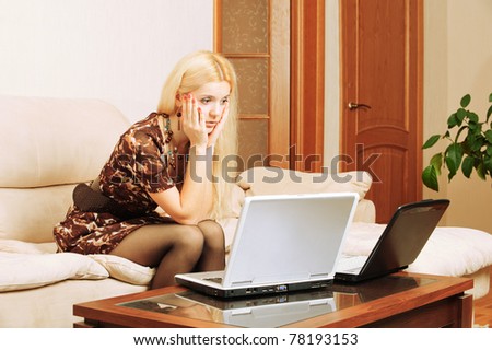 Young charming fair-haired woman works on portable computers.