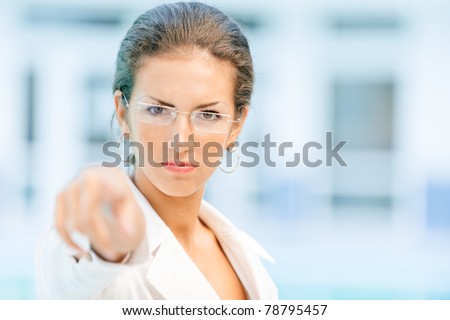 Image of attractive business woman pointing her finger to you.