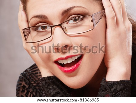 Charming brunette in glasses laughs and props up fists chin.