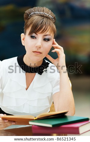 serious young woman student sitting table reading book