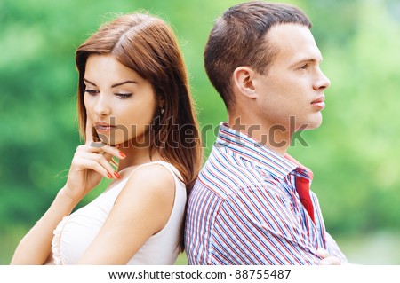 portrait beautiful young man woman couple standing back each other sad background summer green park