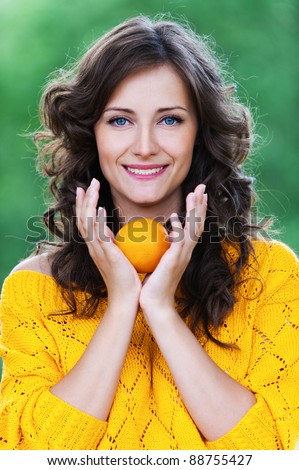 portrait young charming woman standing holding tangerine background summer green park