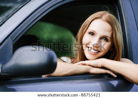 young beautiful young woman sitting car looking out open window smiling