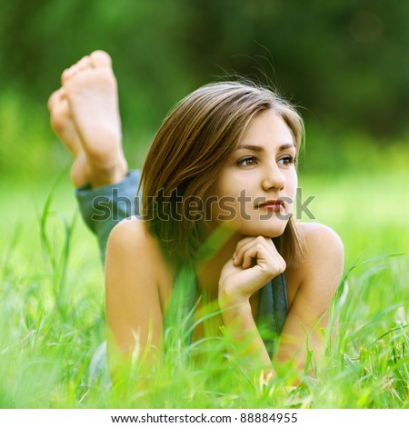 beautiful young woman lying clearing feet up leaning hands dreaming